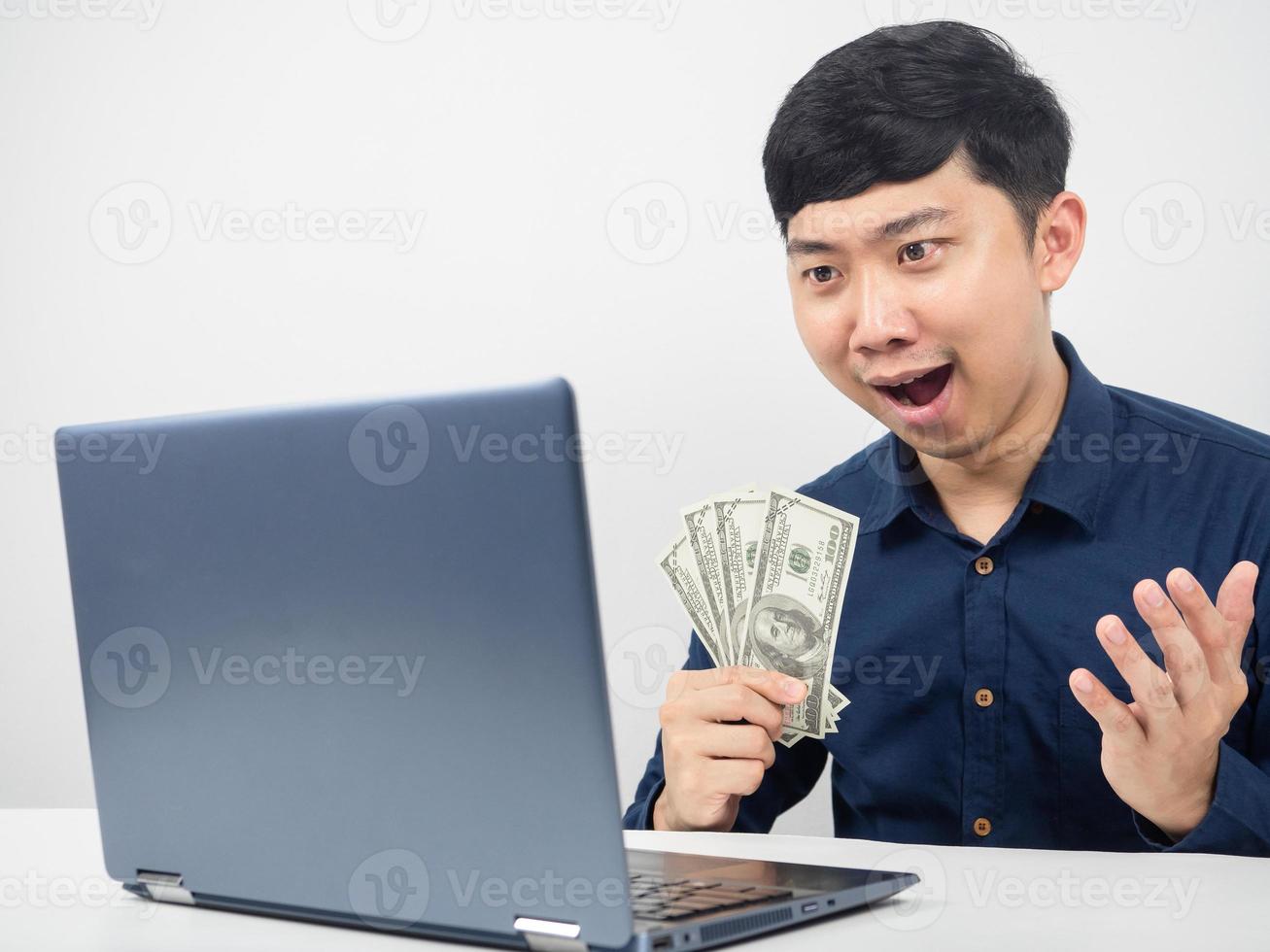 Man sitting and looking at laptop feeling amazed with earn money photo