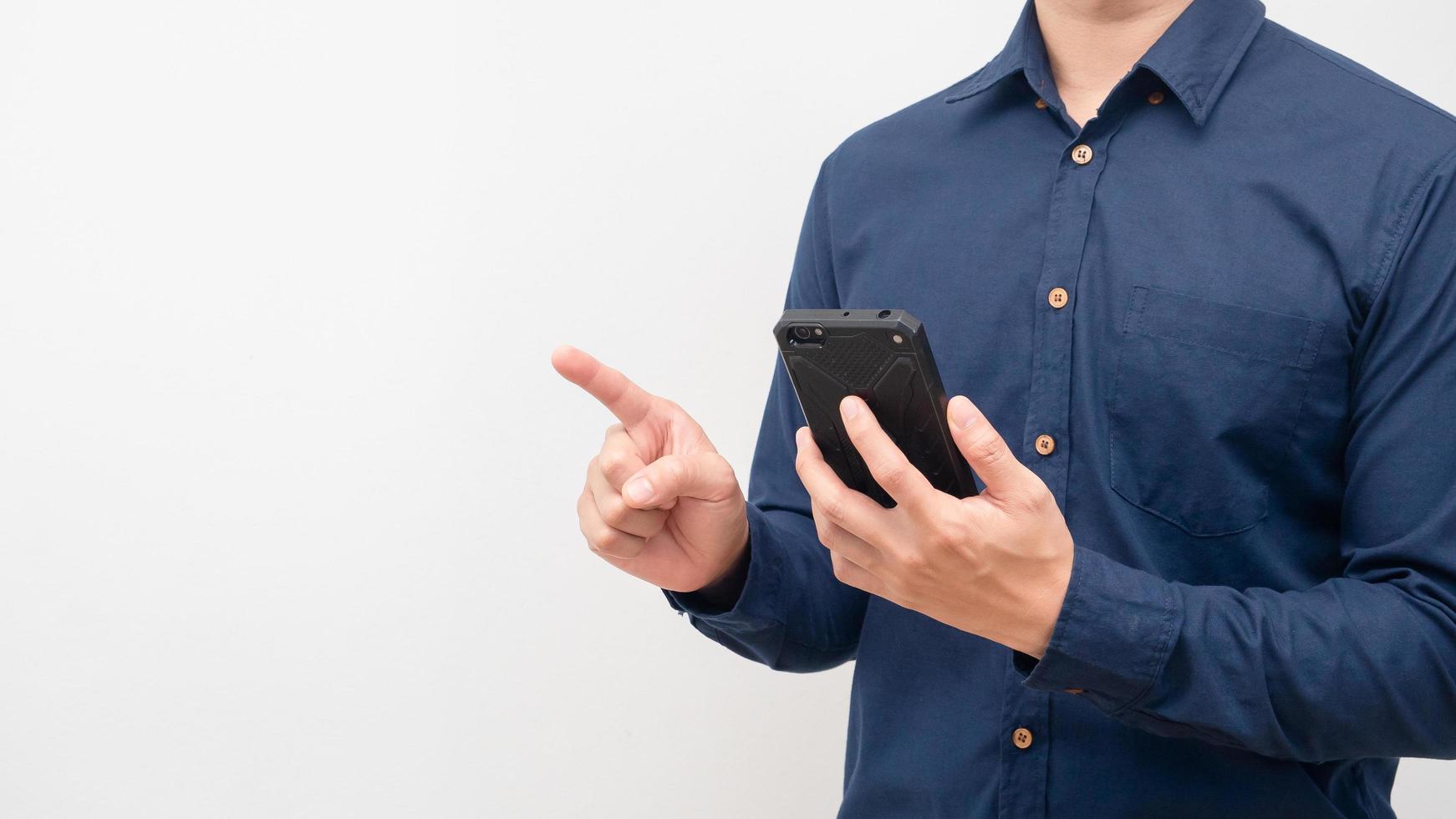Crop shot man holding mobile phone point finger at white background copy space photo