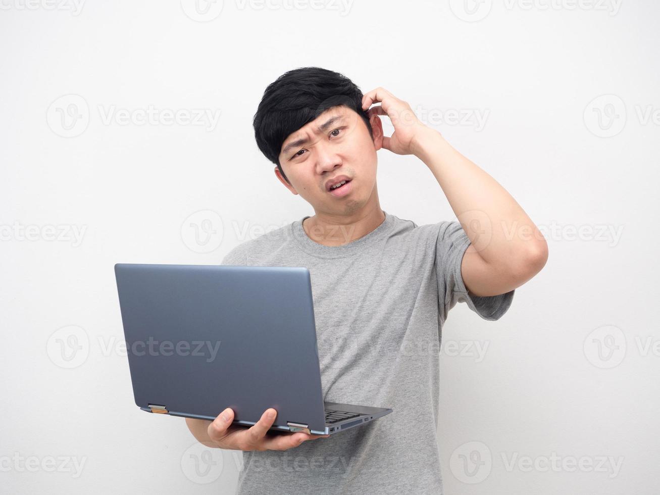 Asian man holding laptop gesture bored looking at camera photo