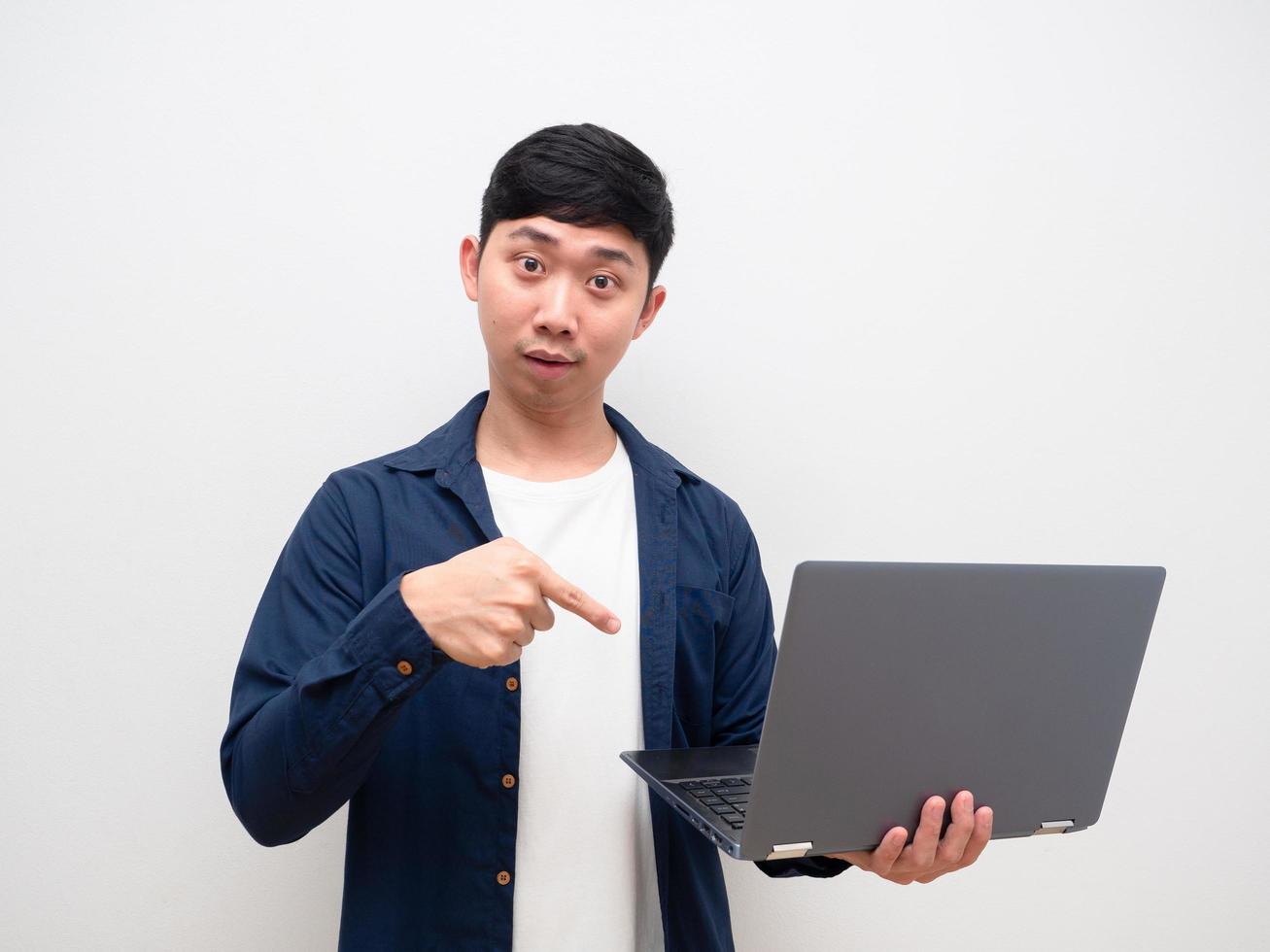 Man feel get idea and point finger at laptop in his hand look at camera on whit background photo