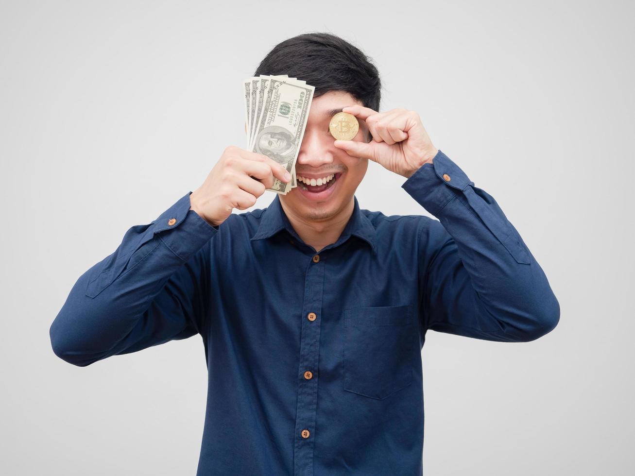 El hombre cierra su rostro con dinero en dólares y oro bitcoin retrato fondo blanco. foto