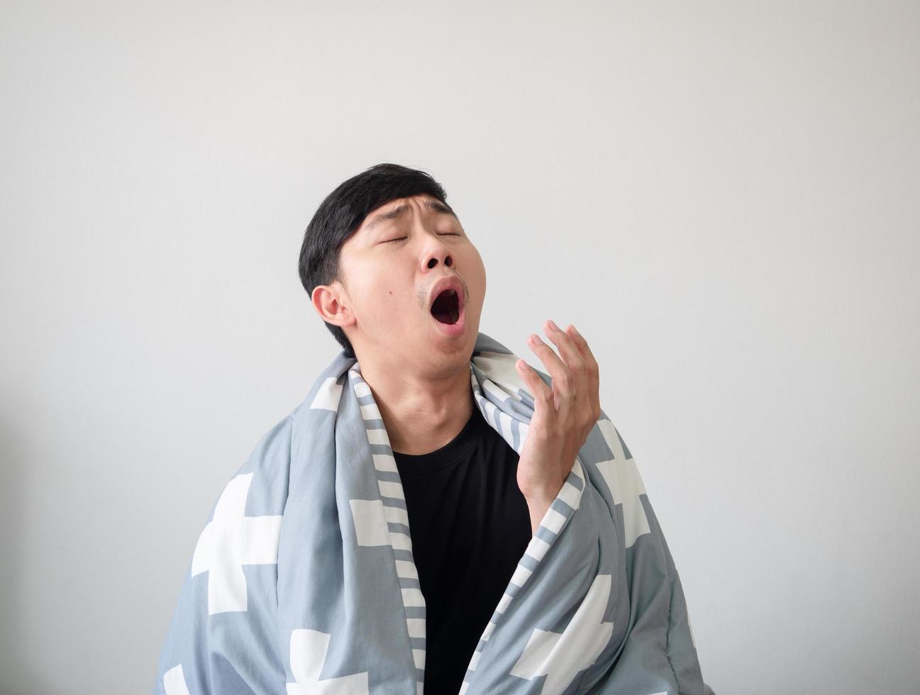 Young man with blanket cover his body wake up and feel sleepy and yawn on white isolated,Sleepy man concept photo
