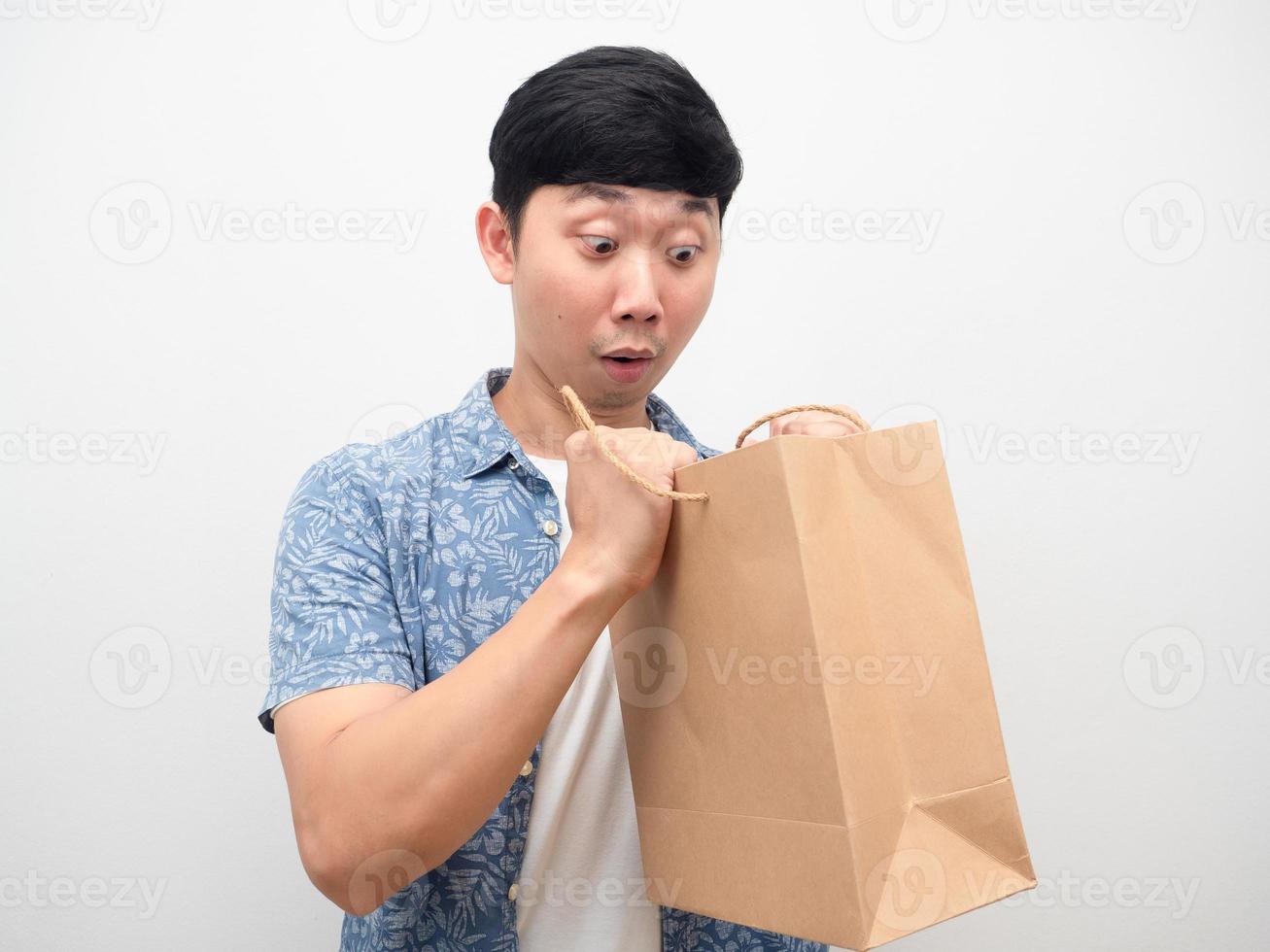 Man feel excited looking at shopping bag in hand photo