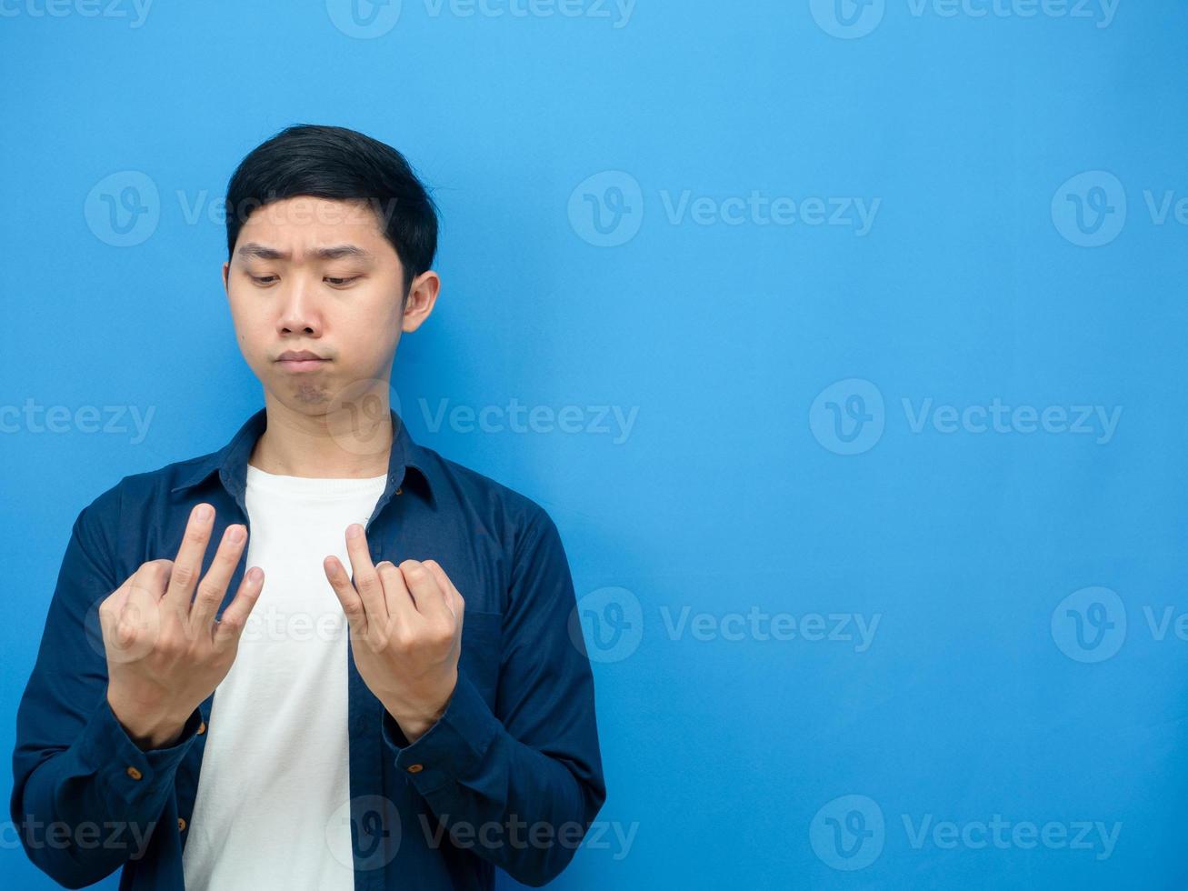 Man counting his finger about something serious face blue background copy space photo