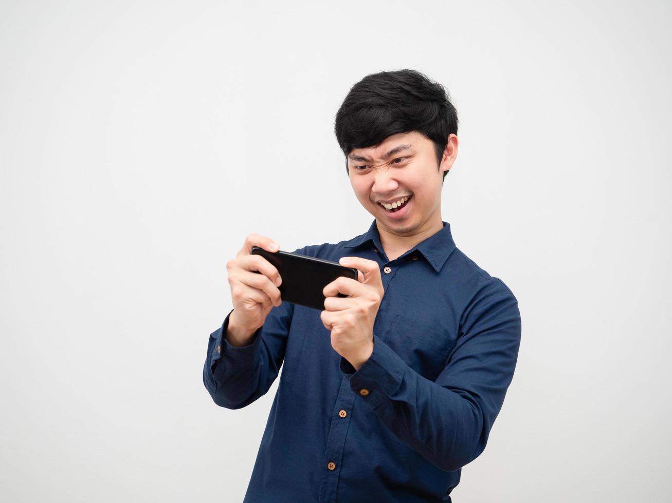 Asian man playing game on mobilephone feeling fun on white background photo