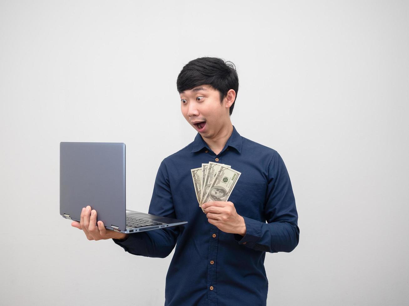Business man asian feeling amazed look at laptop in hand and get money on white background photo