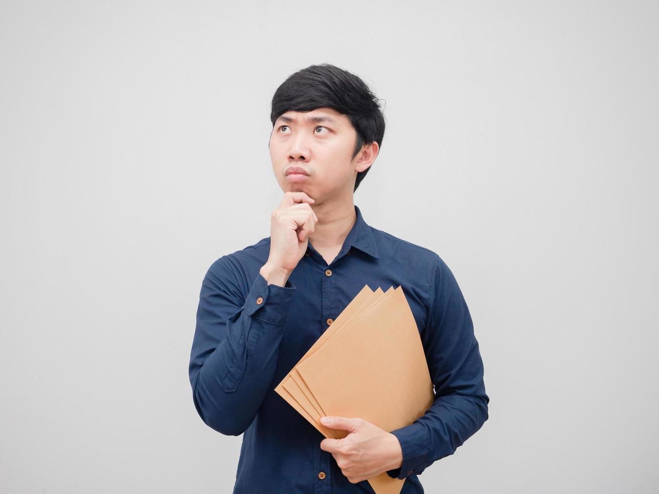 Asian man holding document envelope and thinking something on white background photo