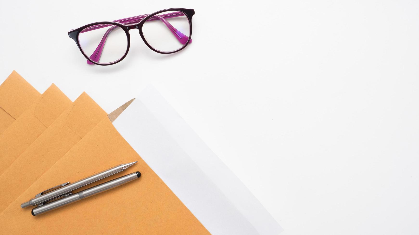 Close up pen on document envelope and glasses on the table top view copy space photo