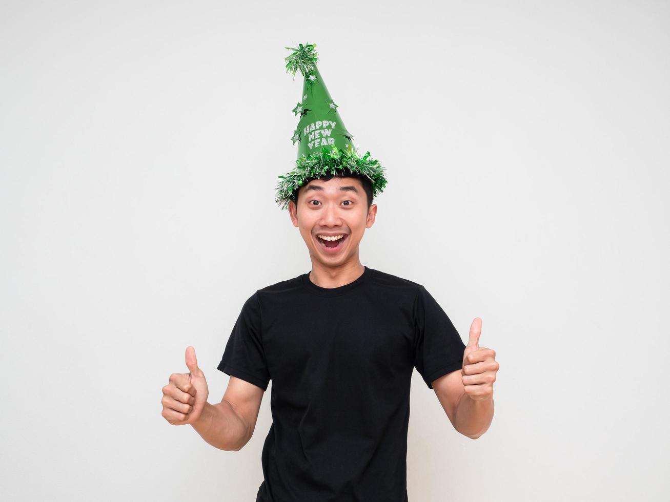 joven asiático con sombrero verde feliz sonrisa alegre doble pulgar hacia arriba sobre fondo blanco aislado celebración feliz año nuevo concepto foto