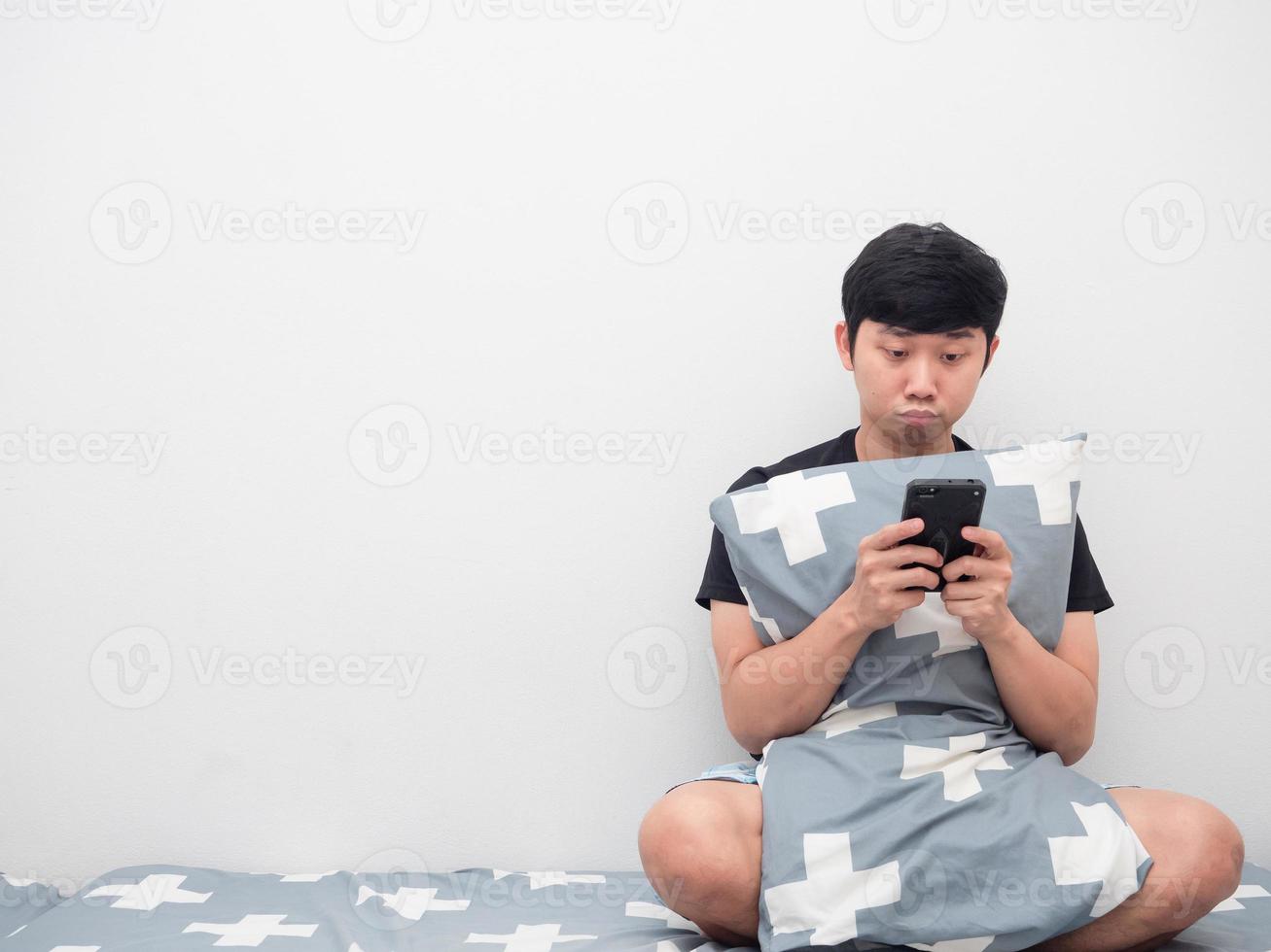 Asian man using moblie phone on the bed copy space photo