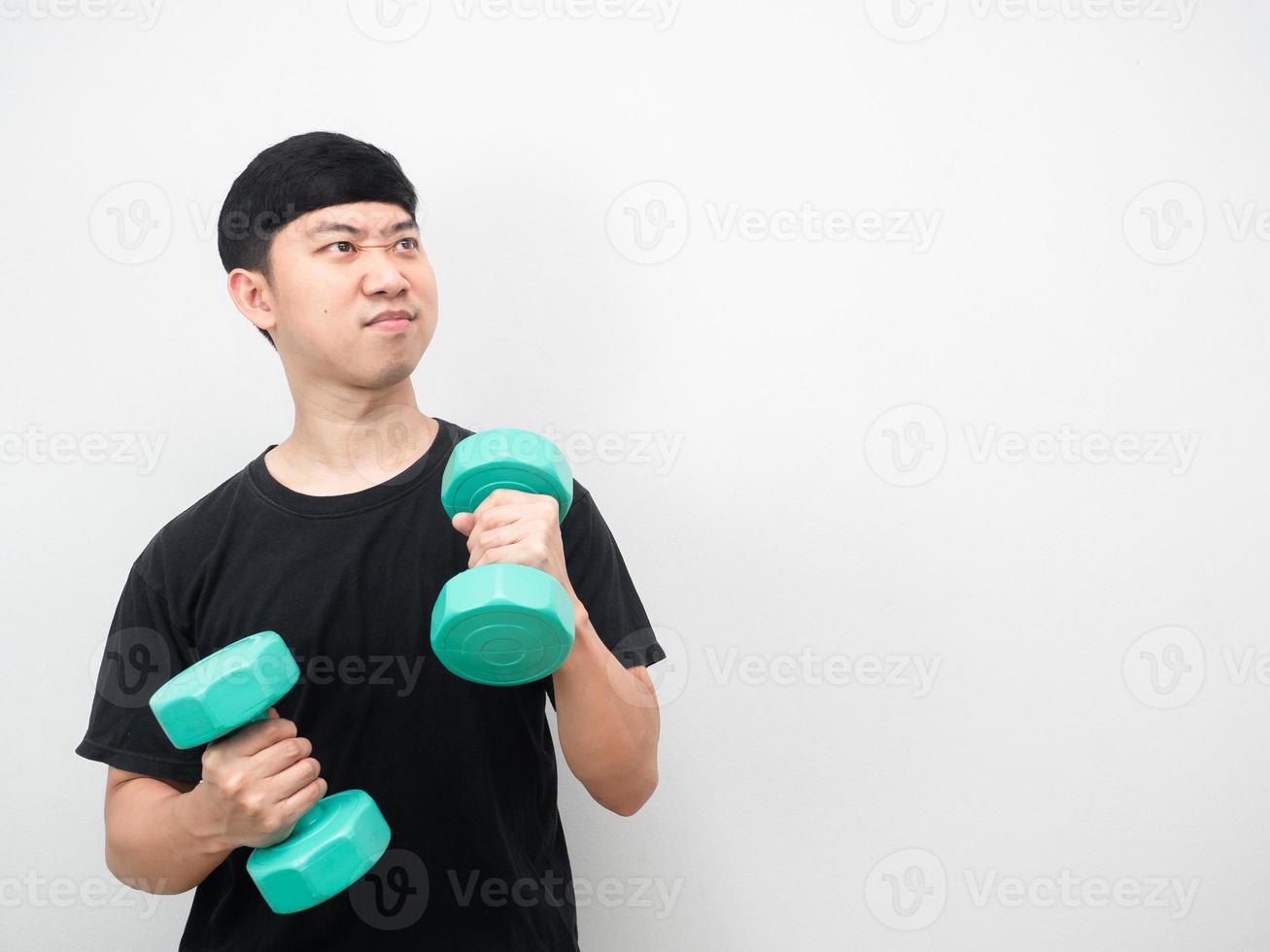 Asian man exercise with dumbbell feeling enjoy and looking at copy space photo