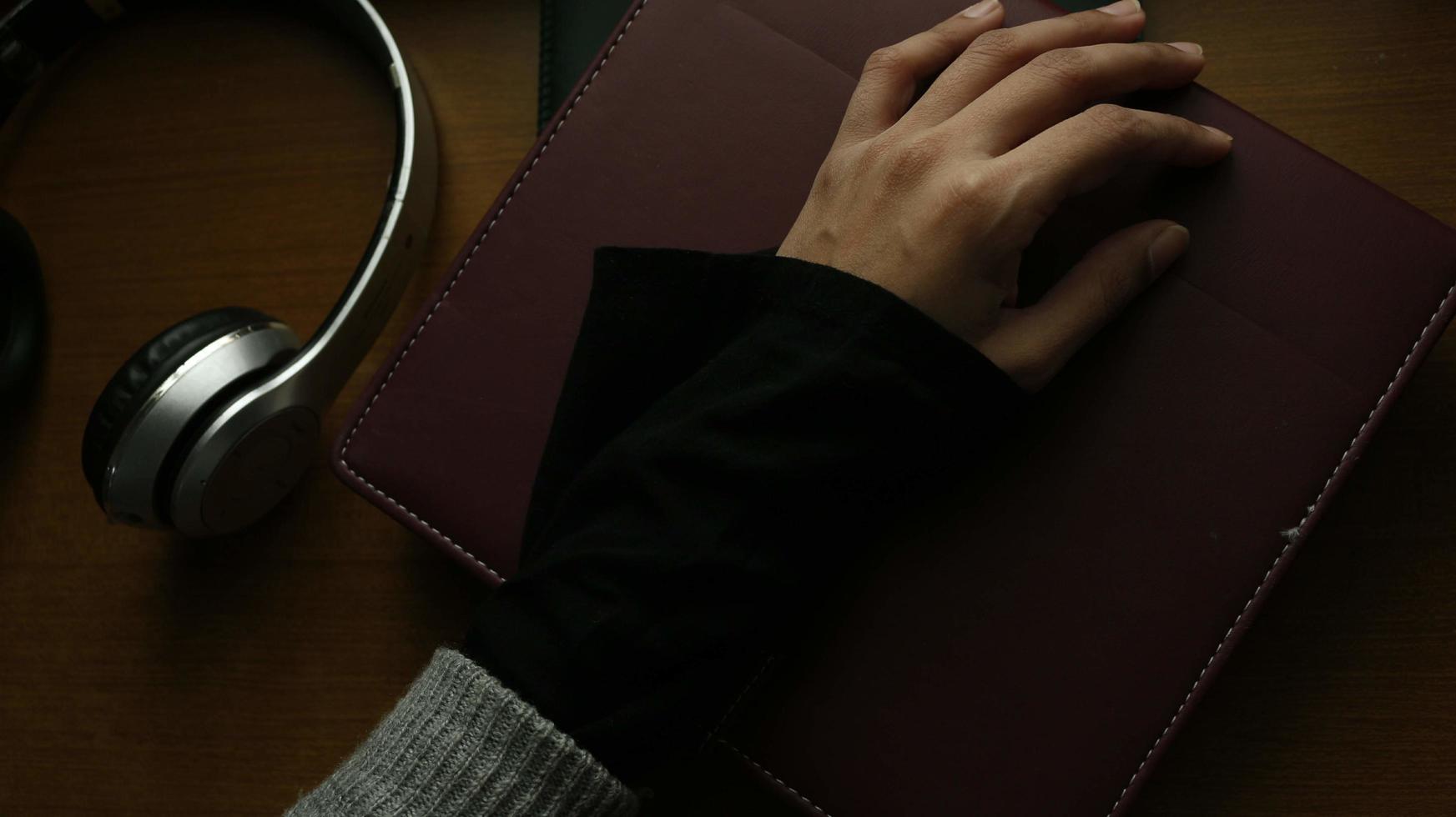 Closeup of a woman's hand on a book in a gloomy setting photo