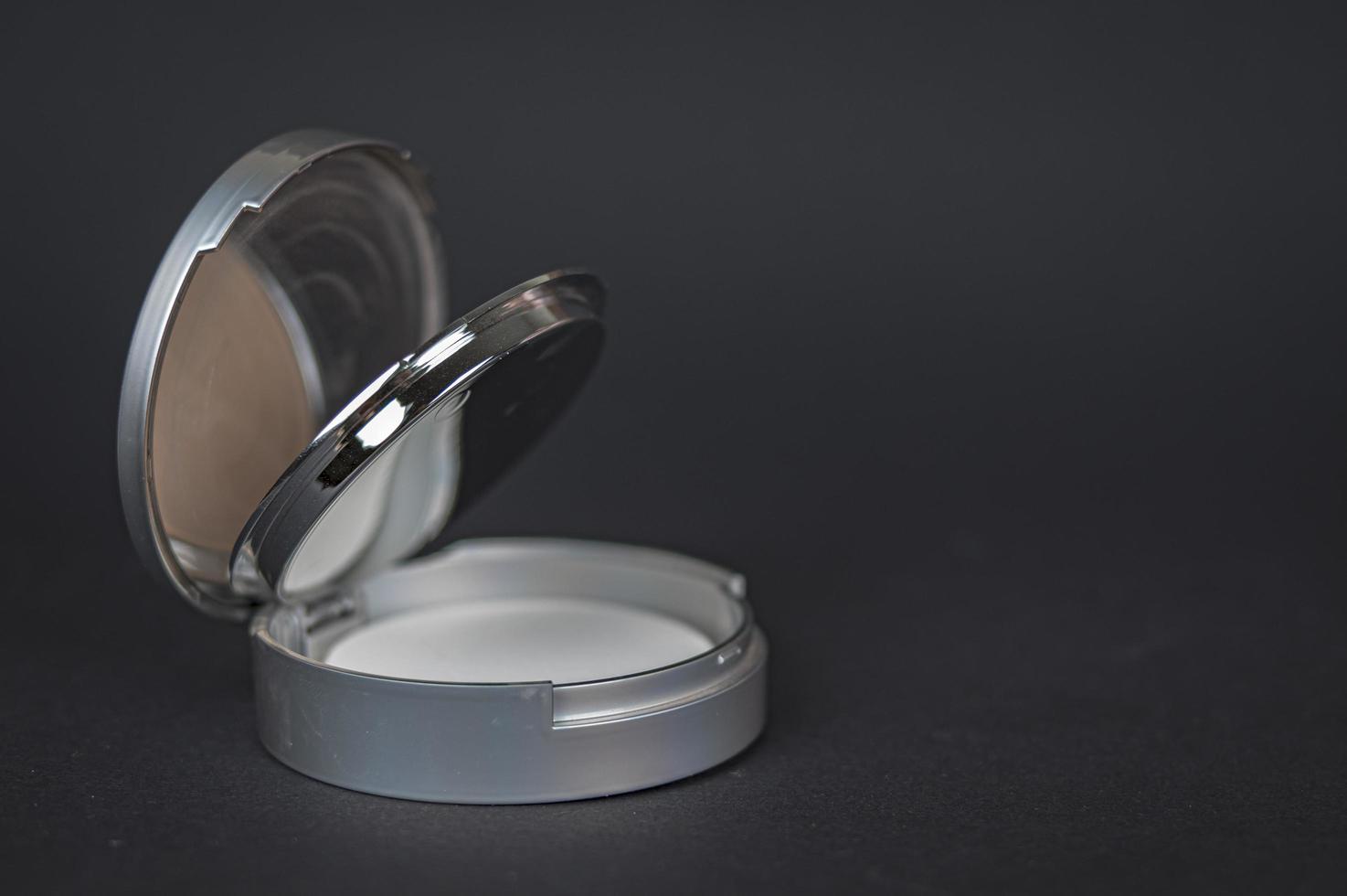 Powder in a round box of light gray color on a dark gray background photo