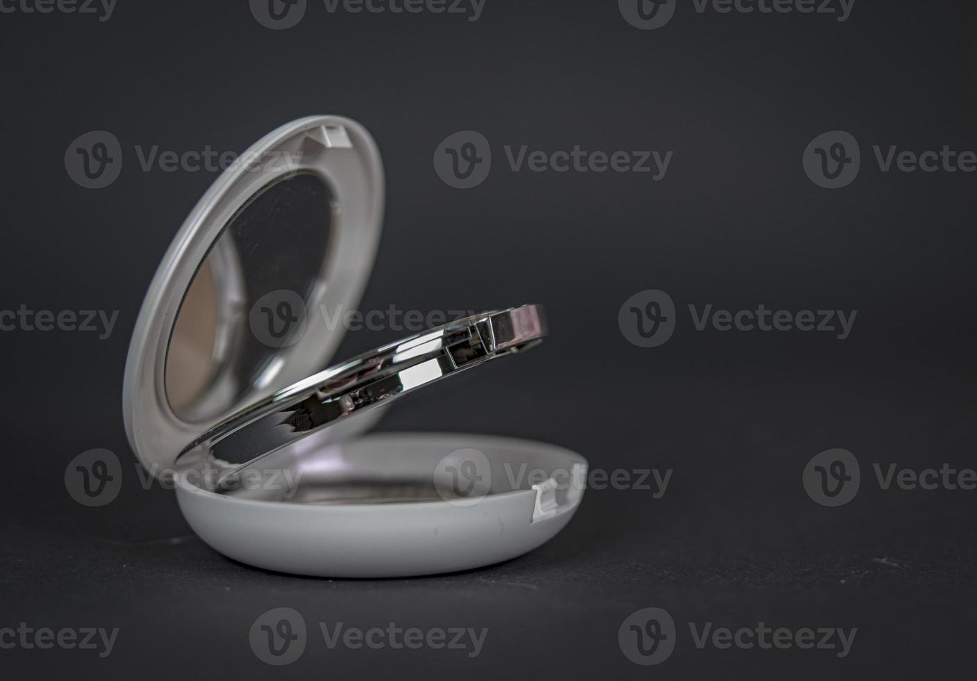 Elite-level compact powder in a round pearl-colored. Open photo