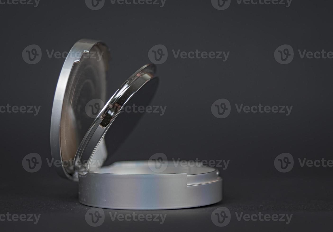 Powder in a round box of light gray color on a dark gray background photo