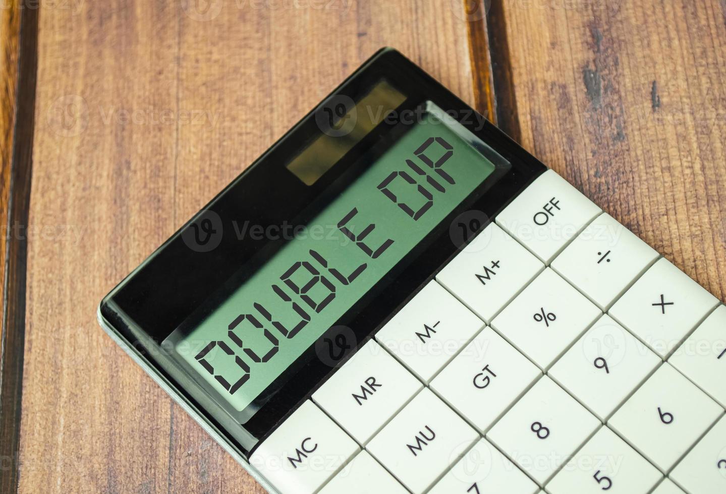 double dip words on calculator display with pen and charts photo