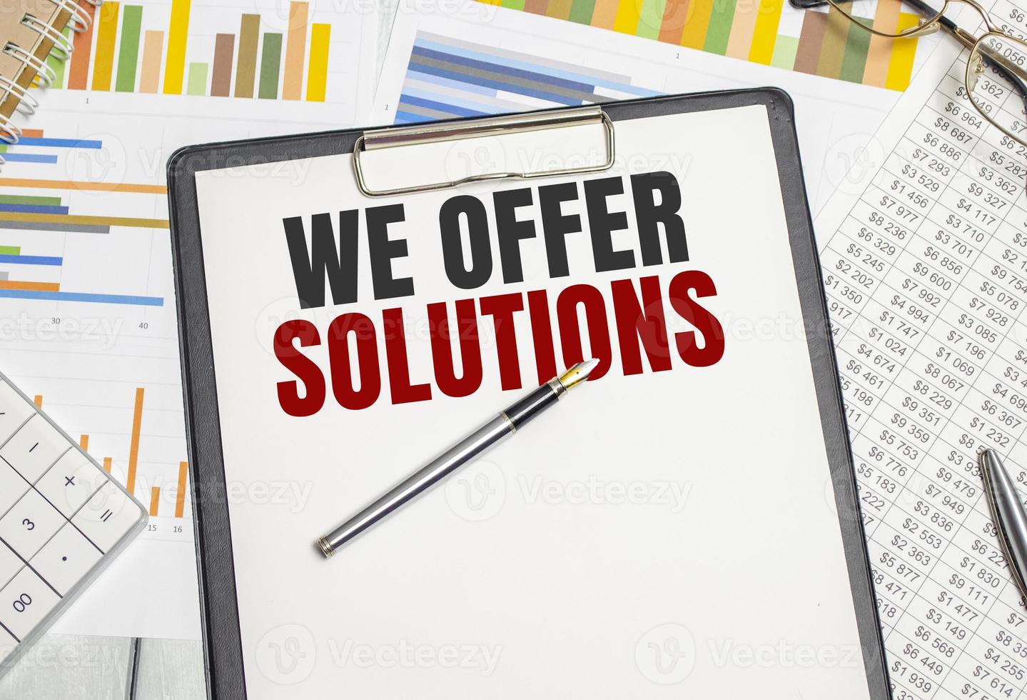 We offer solutions . Conceptual background with chart ,papers and pen photo