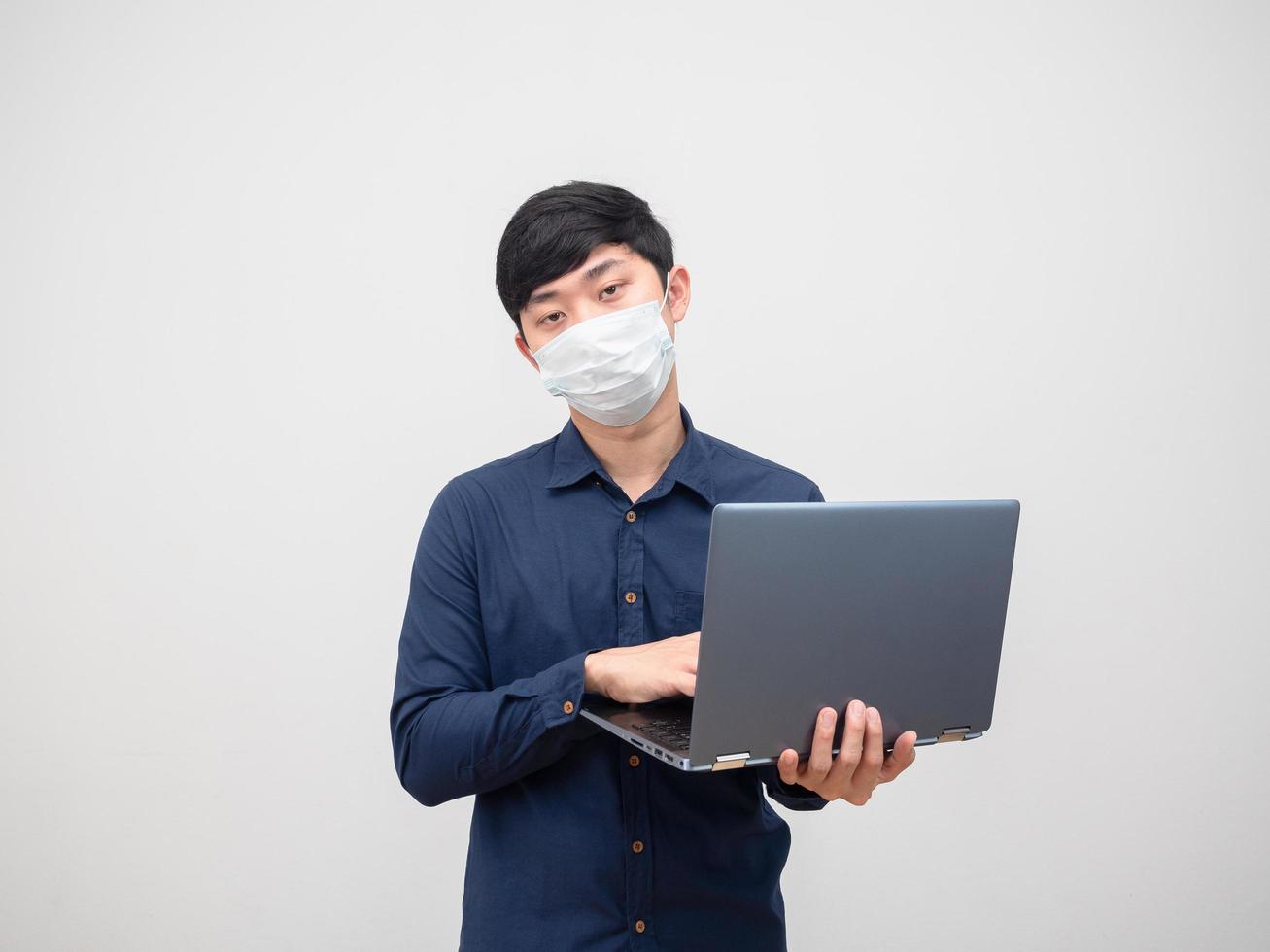 Sick man wearing mask using laptop in his hand unhappy face on white backkground photo