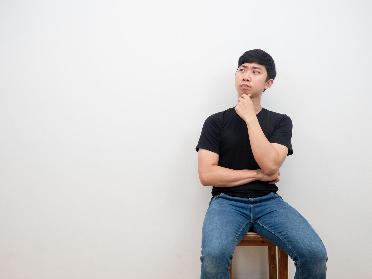 Asian man sitting on chair thinking with serious face on white background decide concept photo