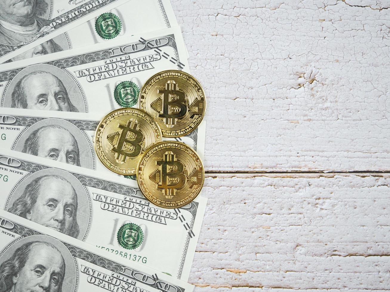 Closeup gold bitcoins on a lot of money on wood table top view copy space photo