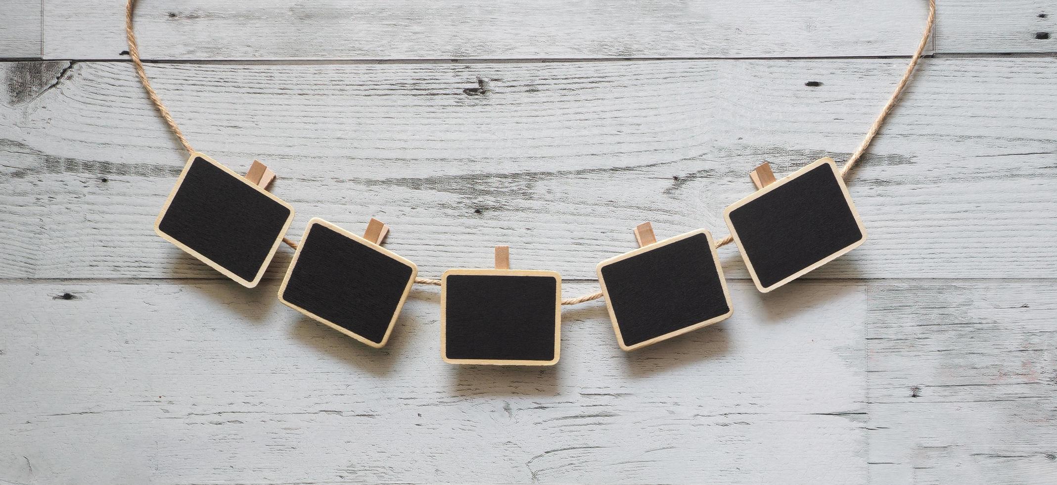 Five small clip chalkboard with rope curve array line on white wood table nature shadow below space,Idea signboard concept photo