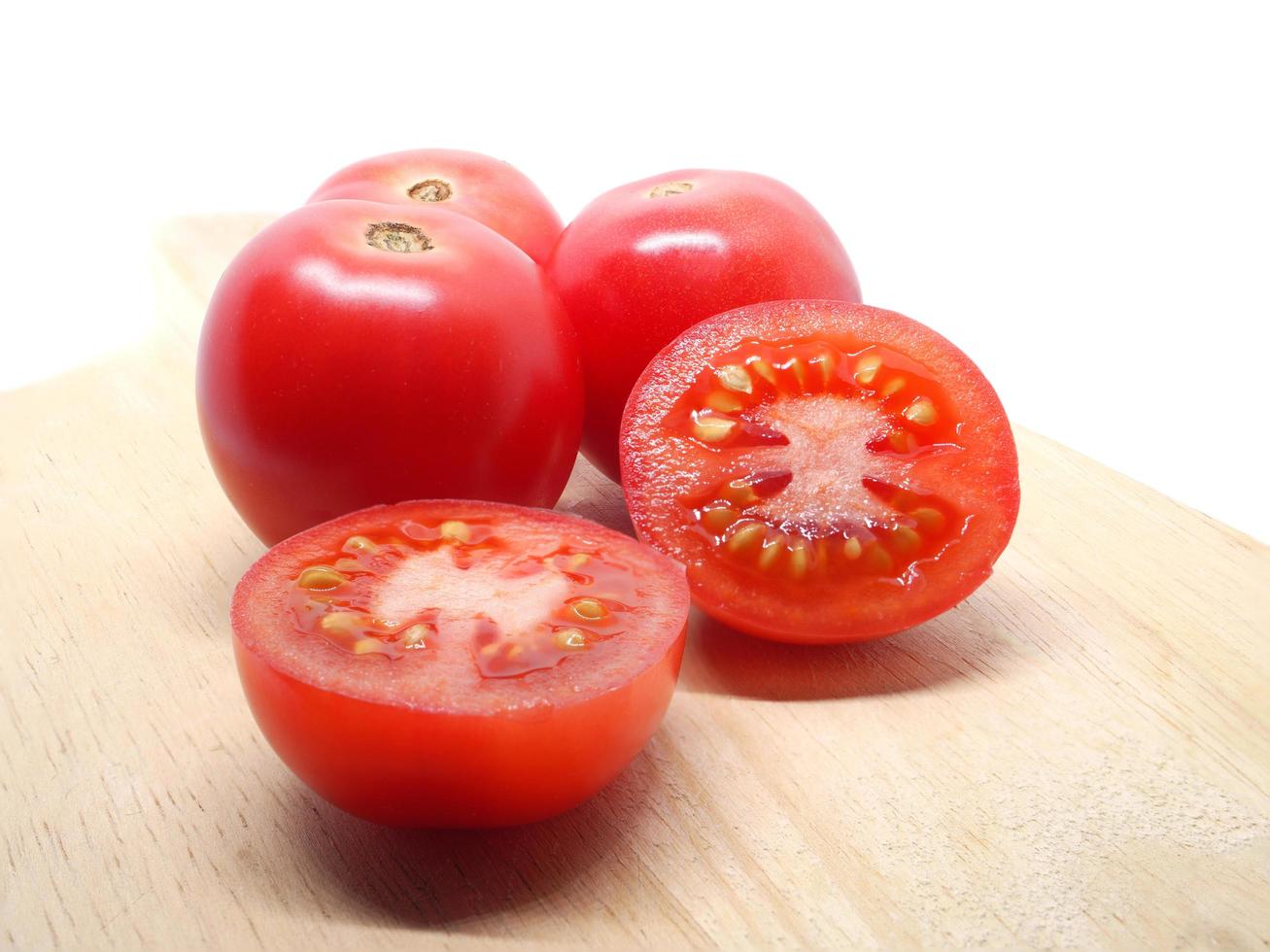 Frescura rodaja de tomate rojo cortado en la sombra de la naturaleza blanca foto