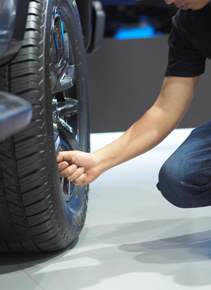 primer plano, hombre, mano, cheking, rueda grande, de, coche nuevo foto