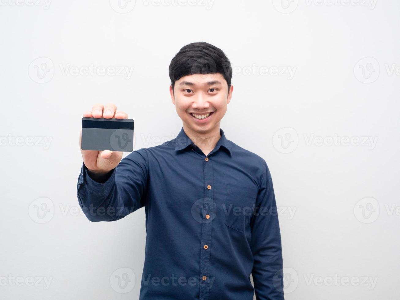 hombre sonriendo y mostrando tarjeta de crédito en la mano foto