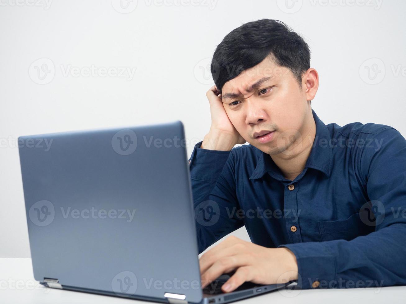 Male employee sitting at office workspace feeling strain looking at laptop photo