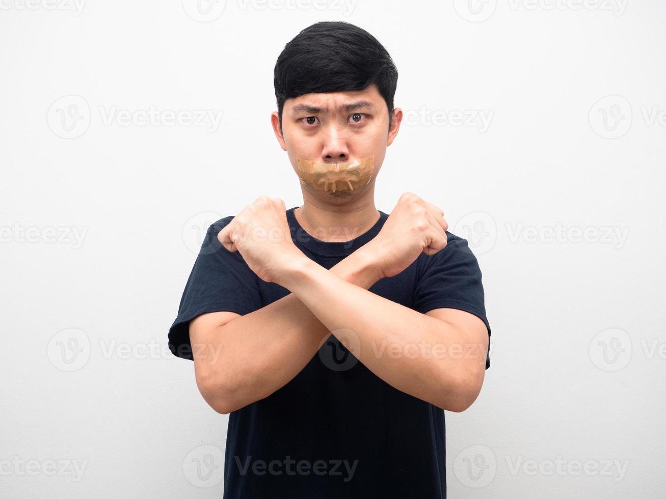 Man gesture cross arm with tape close mouth silence concept photo