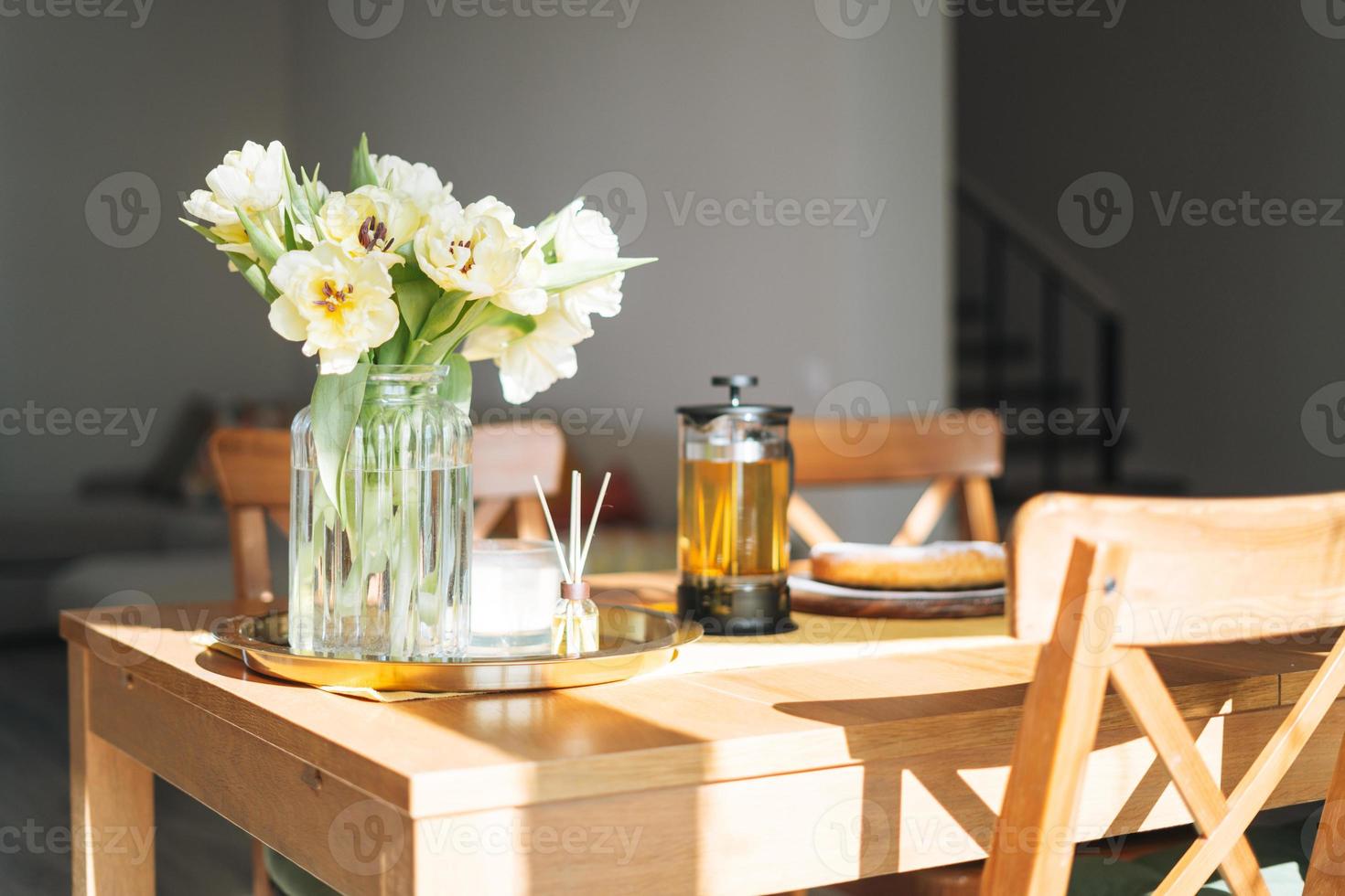 https://static.vecteezy.com/system/resources/previews/016/688/254/non_2x/beautiful-bouquet-of-yellow-tulips-in-vase-on-dinner-table-in-white-kitchen-light-interior-at-the-home-photo.jpg
