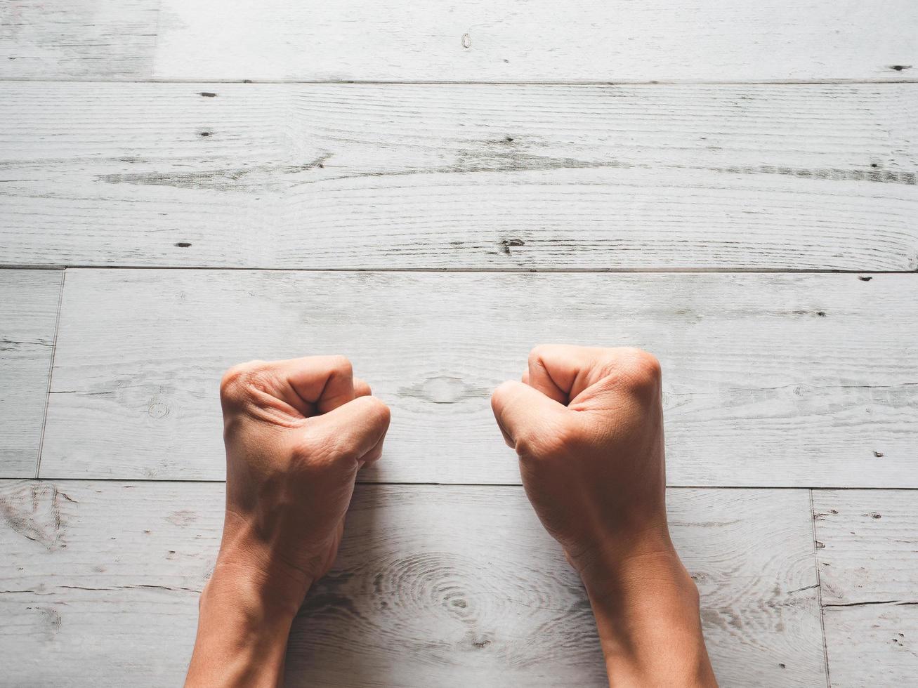 Two fist hand on white wooden table top view copy space photo