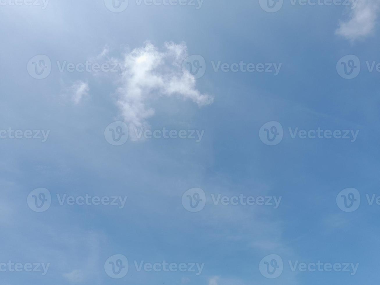 White clouds in the blue sky. Heaven and infinity. Beautiful bright blue background. Light cloudy, good weather. Curly clouds on a sunny day. photo