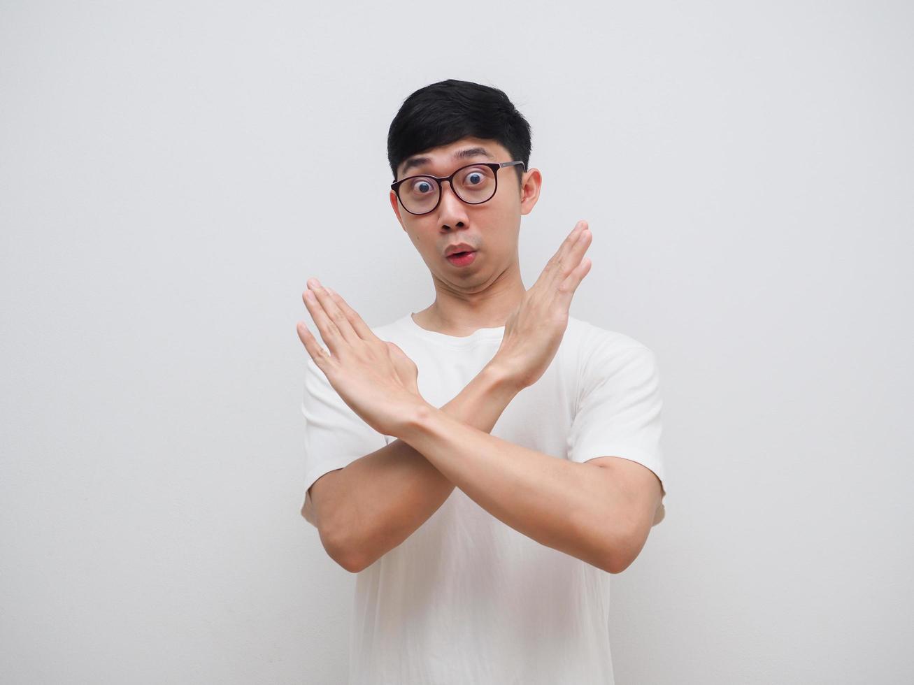 el hombre de las gafas dice que no y cruza los brazos hacia arriba con la camisa blanca mira la cámara sobre un fondo blanco aislado foto