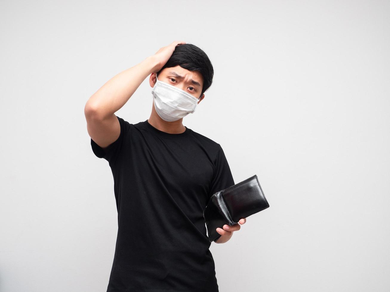 Asian man wearing  protect mask holding wallet and touch his head feeling sad nad bored on white background photo