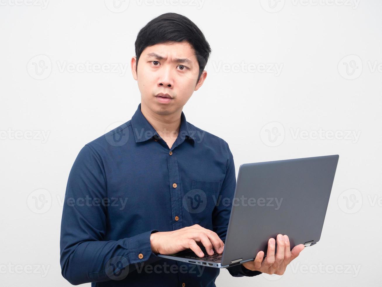 Asian man holding laptop serious face looking at camera photo