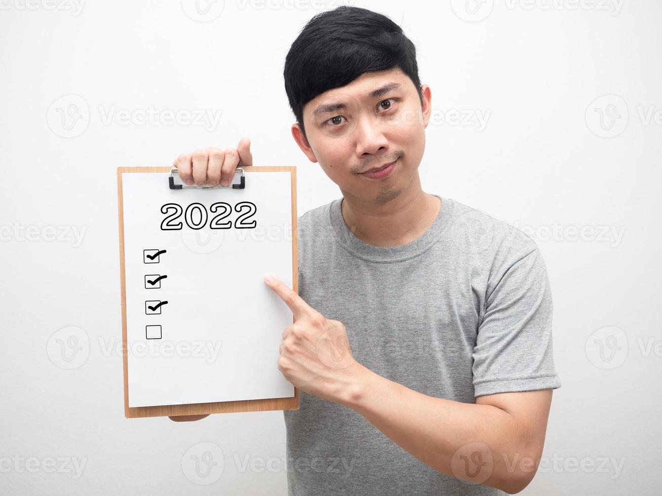 Man point finger at document wood board with 2022 message and check list photo