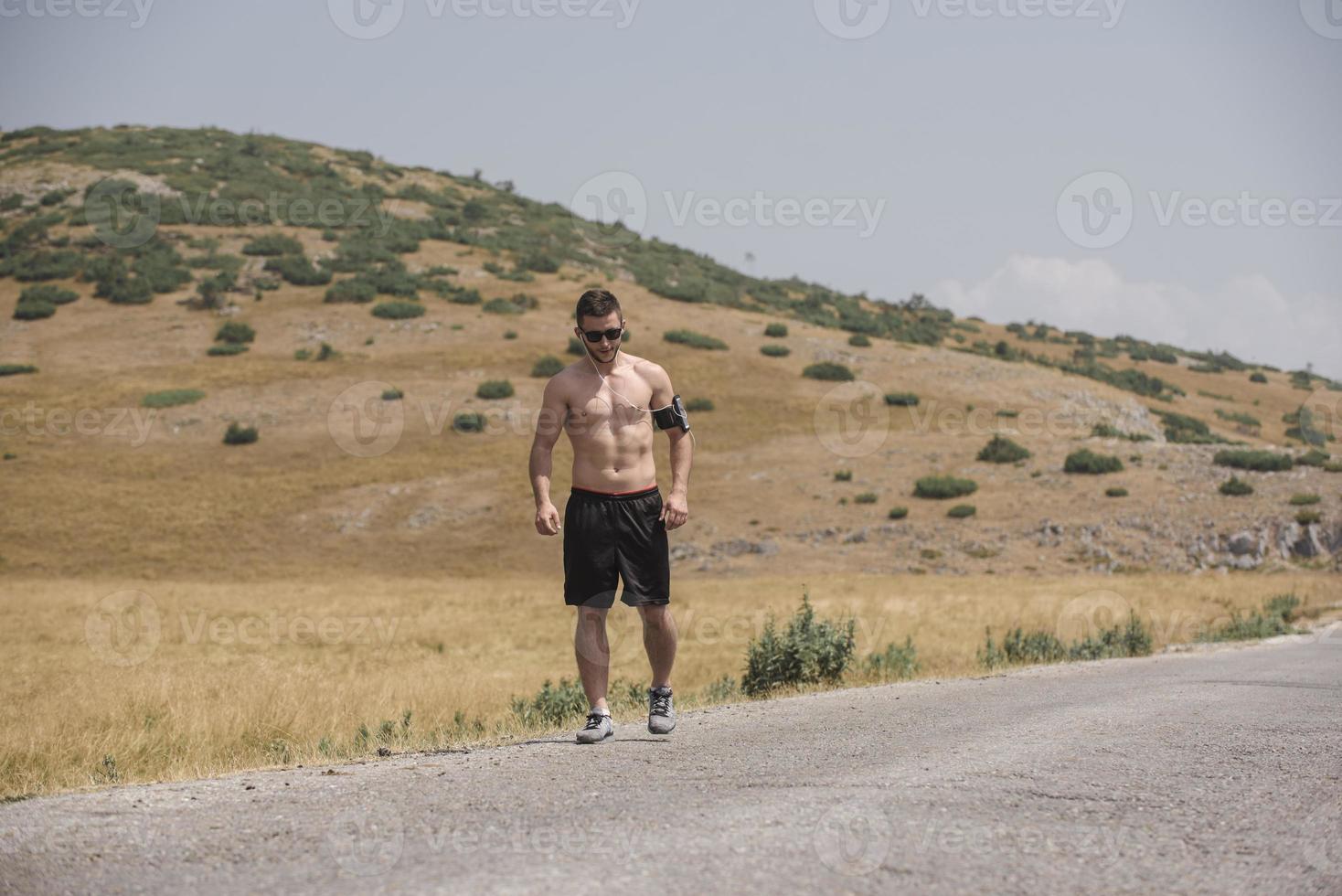 Young man runner running on a mountain road. Jogger training workout in fitness shoe. Healthy lifestyle and sport concept.  Motion blur and selective focus. photo