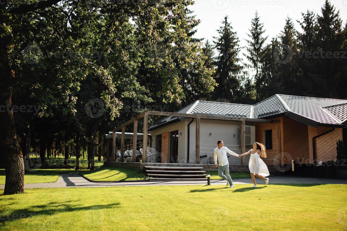 loving young couple having fun outdoors in summer sunny day. Man and woman are running near cafe in park. valentines day photo