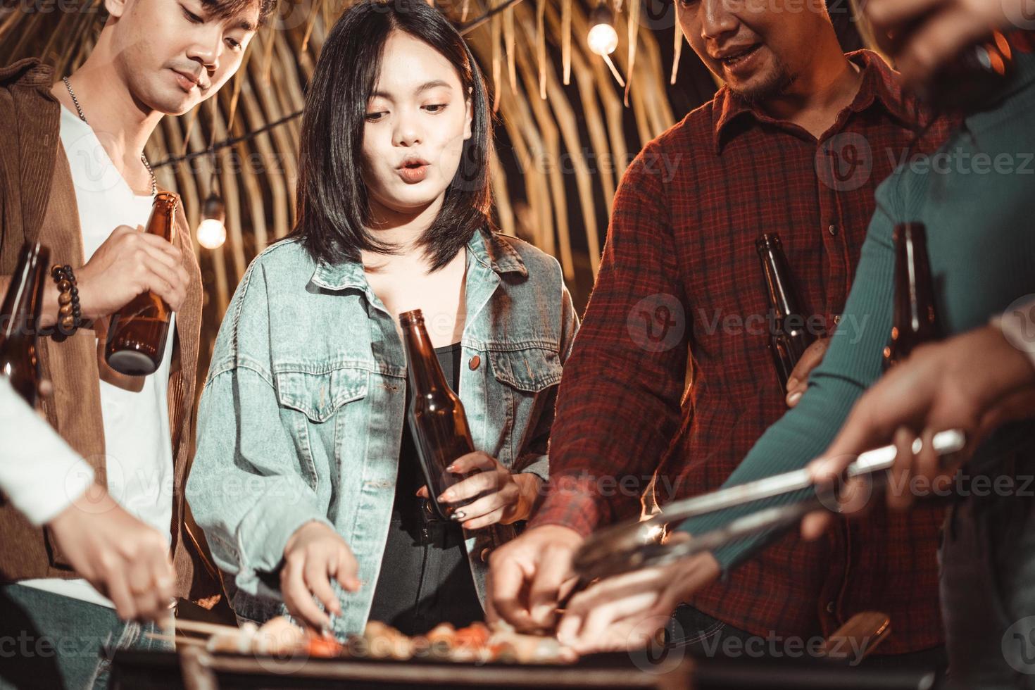 Group of Asian friends having a barbecue in the backyard. photo