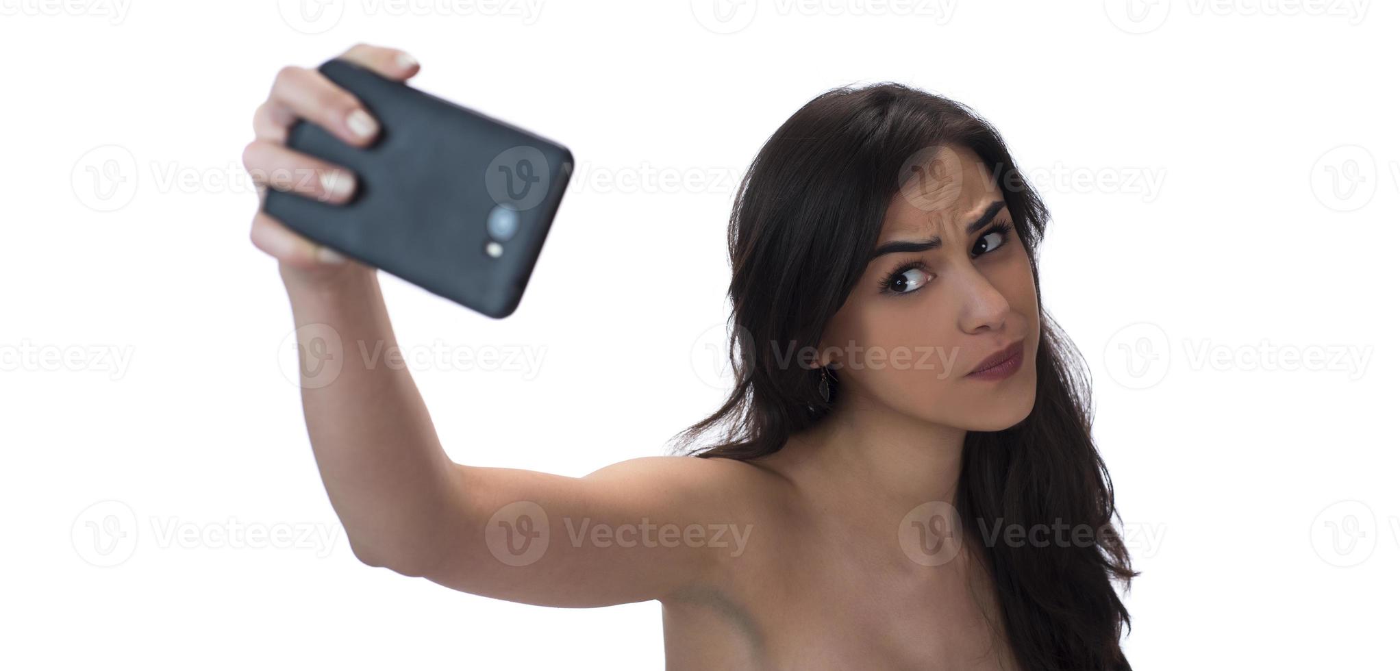 Image of beautiful brunette woman laughing while taking selfie photo on cellphone isolated over white background