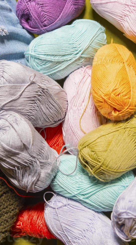 Colorful balls of wool on wooden table. Variety of yarn balls, view from above. photo