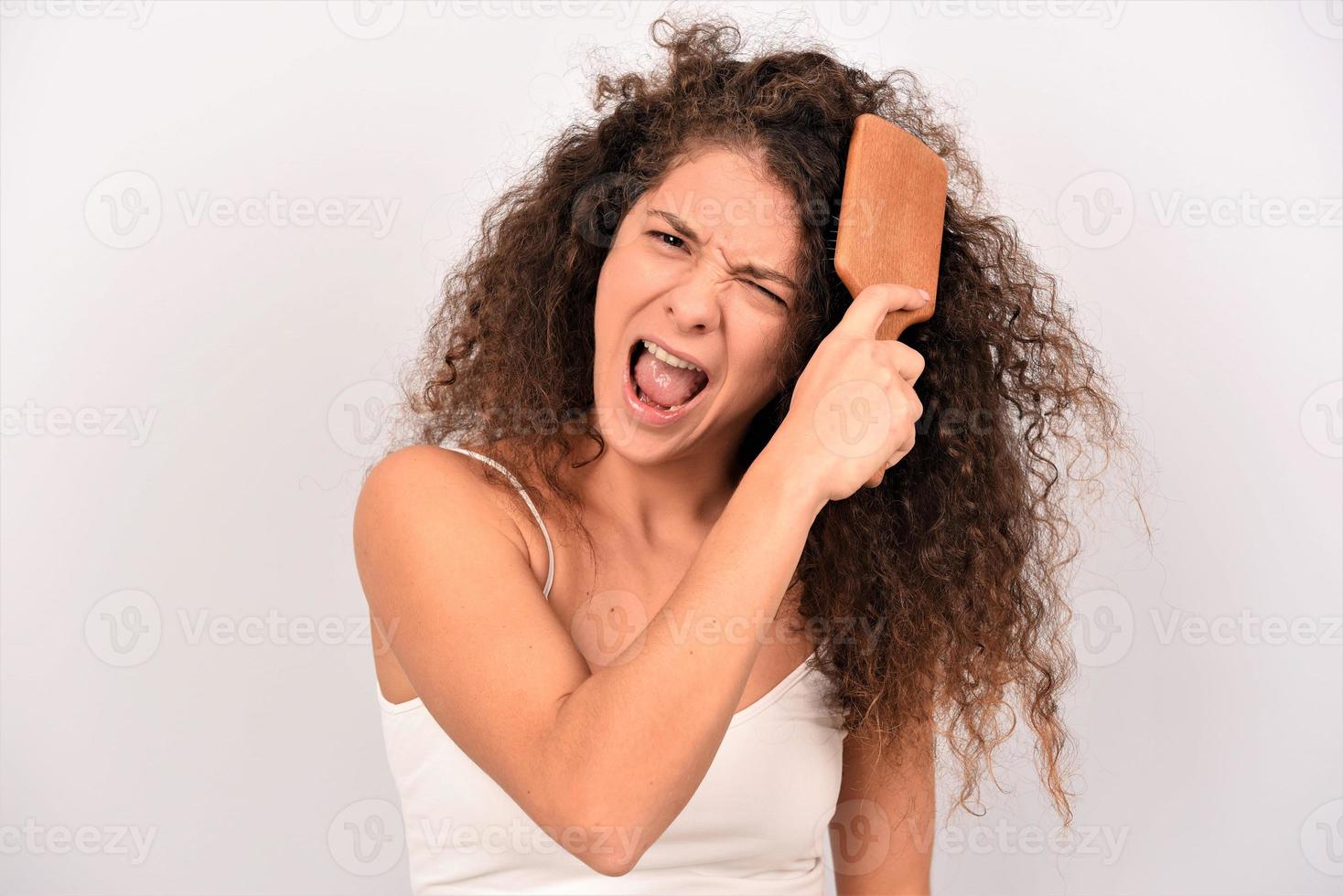 lindo lindo encantador atractivo alegre alegre positivo modelo de niña de cabello ondulado peinando rizos foto