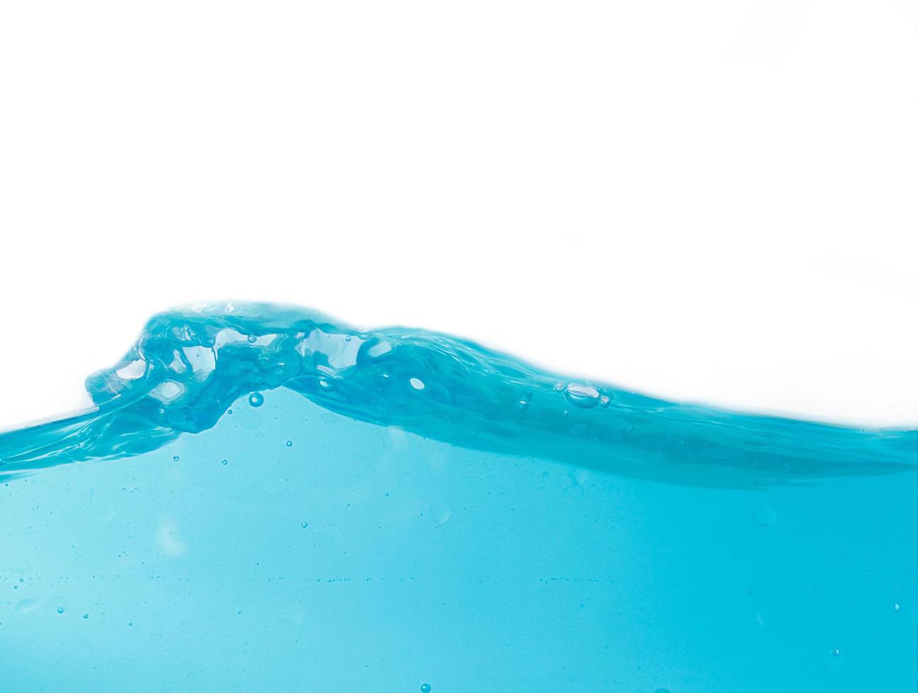 salpicaduras de agua azul y burbujas sobre un fondo blanco, agua azul clara y olas foto