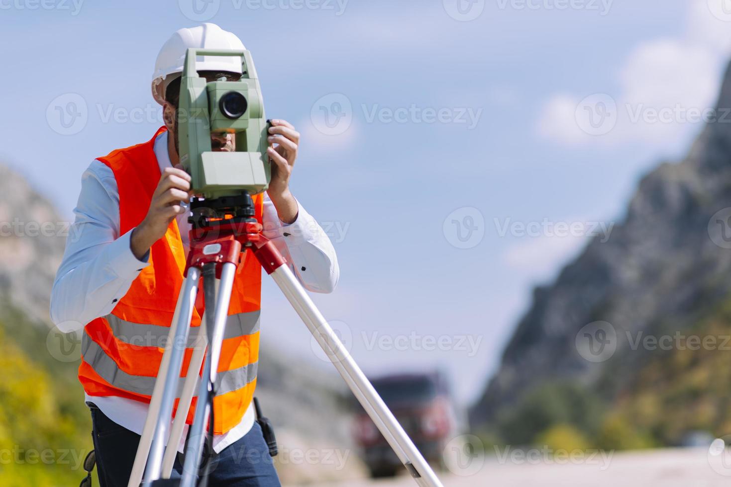 el ingeniero topógrafo está midiendo el nivel en el sitio de construcción. los topógrafos aseguran mediciones precisas antes de emprender grandes proyectos de construcción. foto