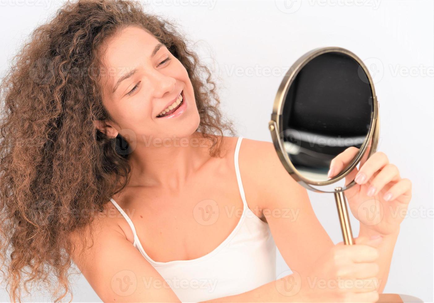 young woman in front of the mirror checking her face skin photo