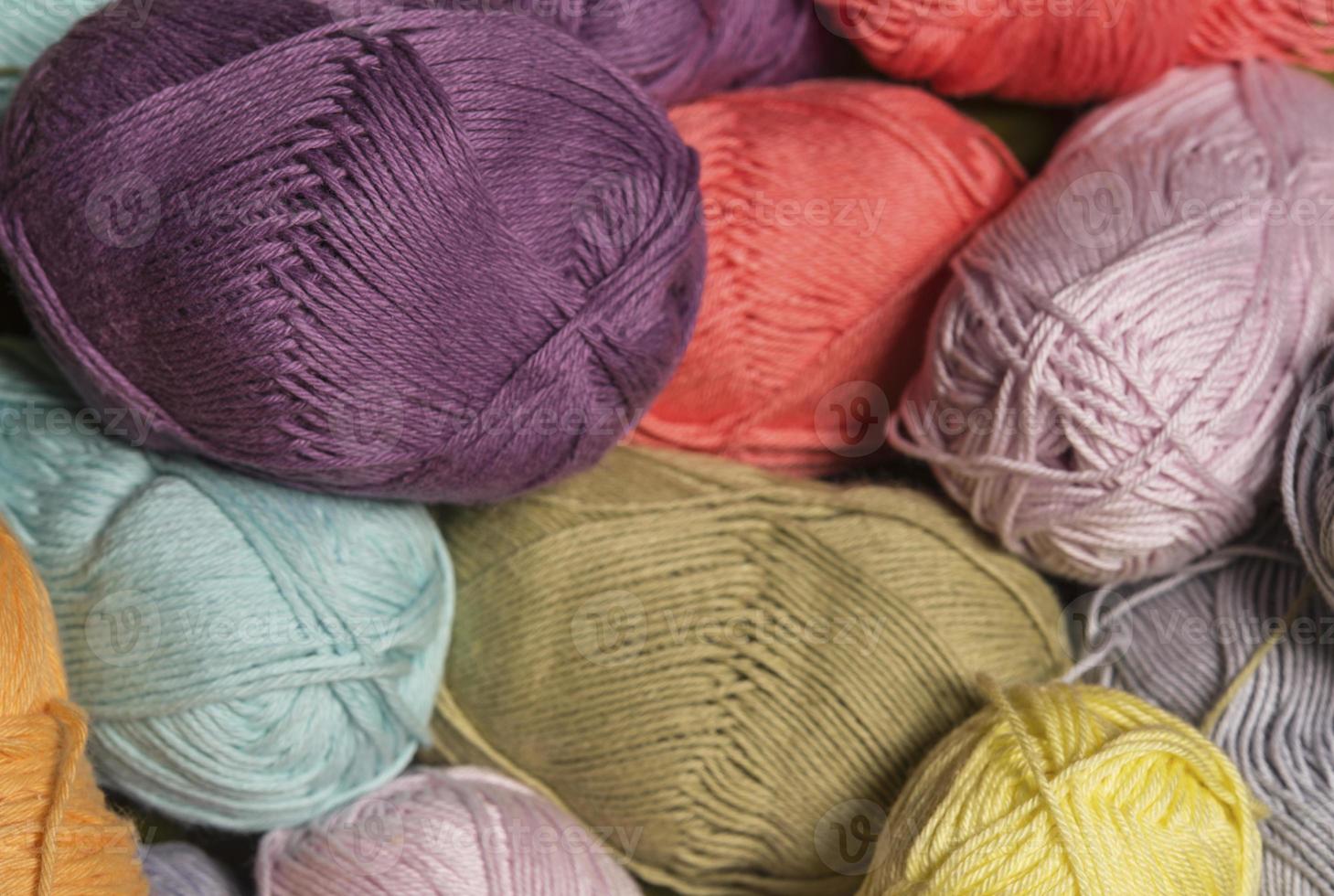 Colorful balls of wool on wooden table. Variety of yarn balls, view from above. photo