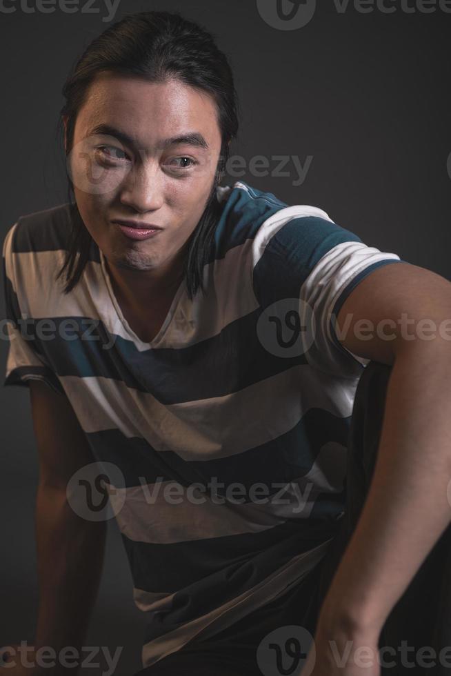 Guapo hombre asiático de moda posando en el estudio sobre fondo negro, concepto de estilo de vida de la gente moderna foto