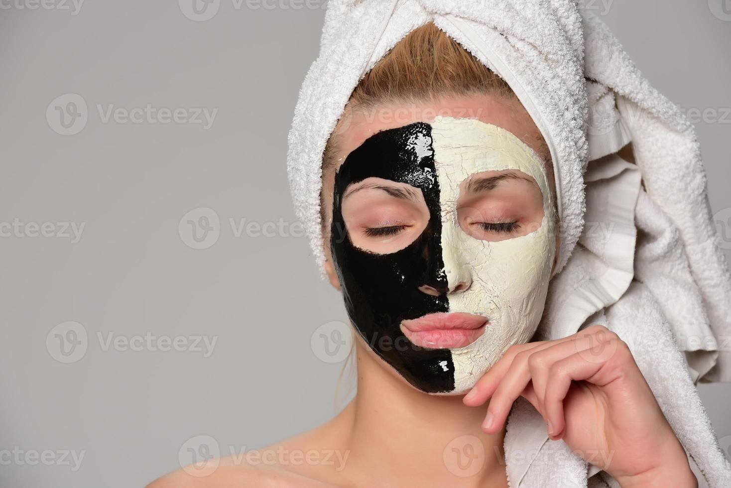 beautiful female model with black and white facial cosmetic mask photo