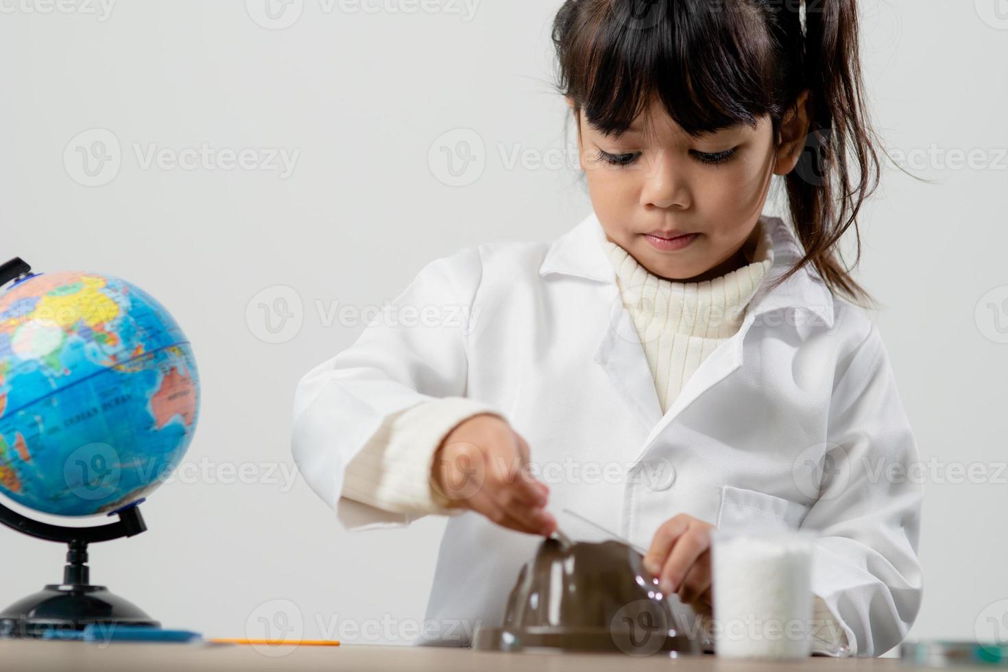 education, science, chemistry and children concept - kids or students with test tube making experiment at school laboratory photo